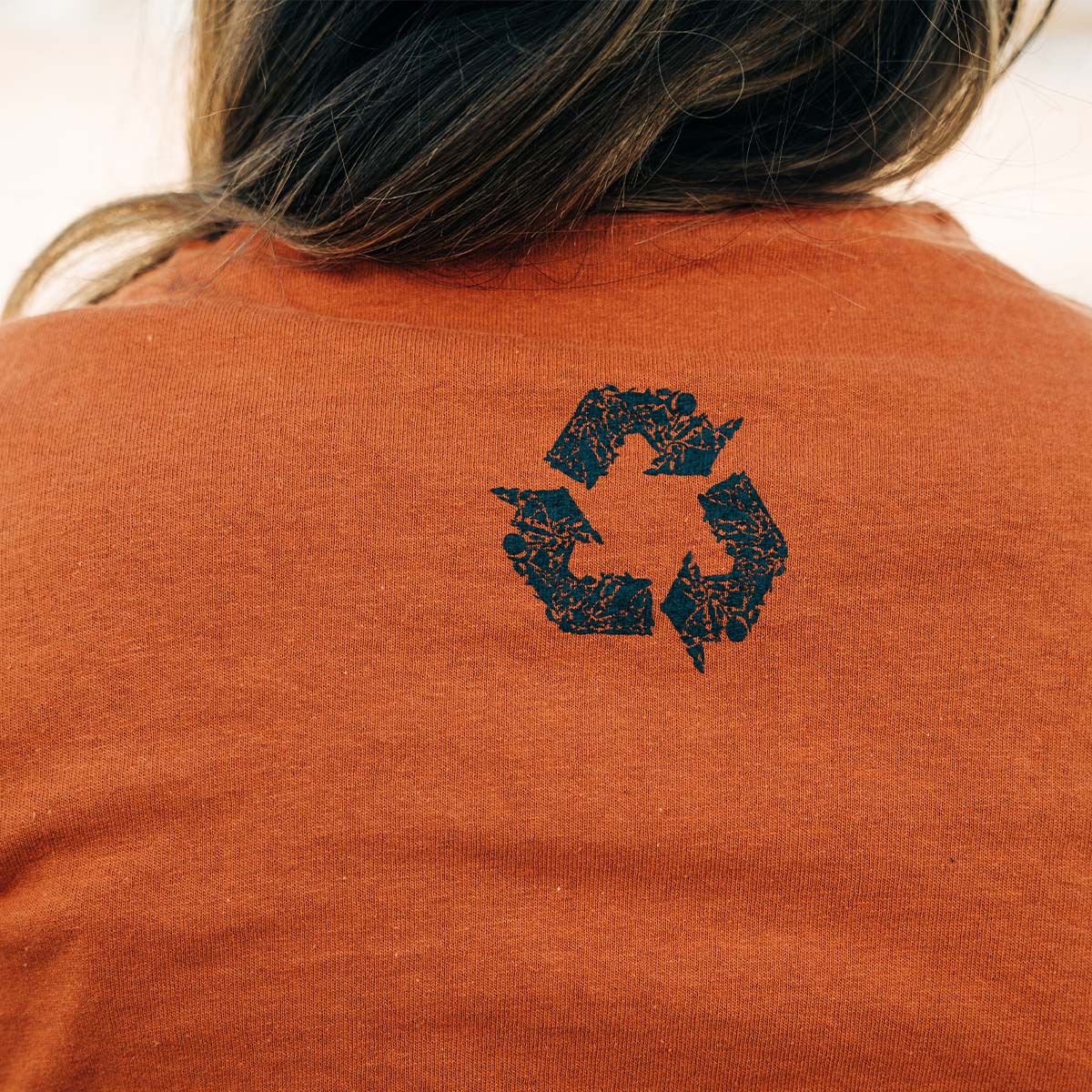 Burnt orange short sleeve tee with Sea Green Apparel navy box logo and small recycle logo on front chest and navy signature recycle logo on center neck 5.3 Ounce, 100% Heavy Cotton Seamless double-needle 7/8" collar Double-needle sleeves and hem